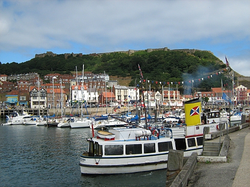 Scarborough Harbour with boats and small ships and the castle walls in the background