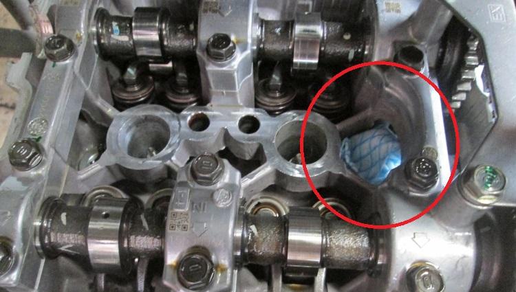 A J cloth is stuffed into the cylinder head to stop shims dropping into the engine