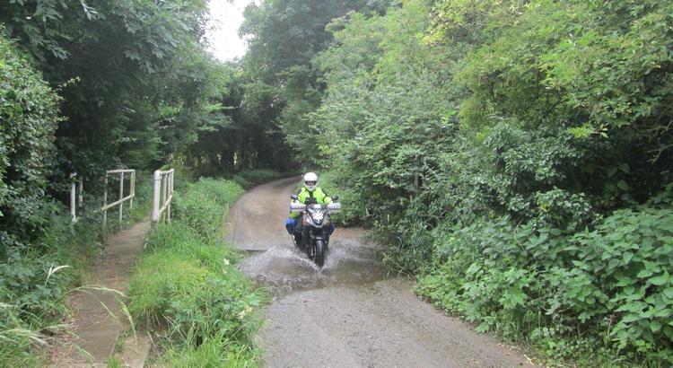 Ren splashes through a tiny little ford on his motorcycle in Folkingham