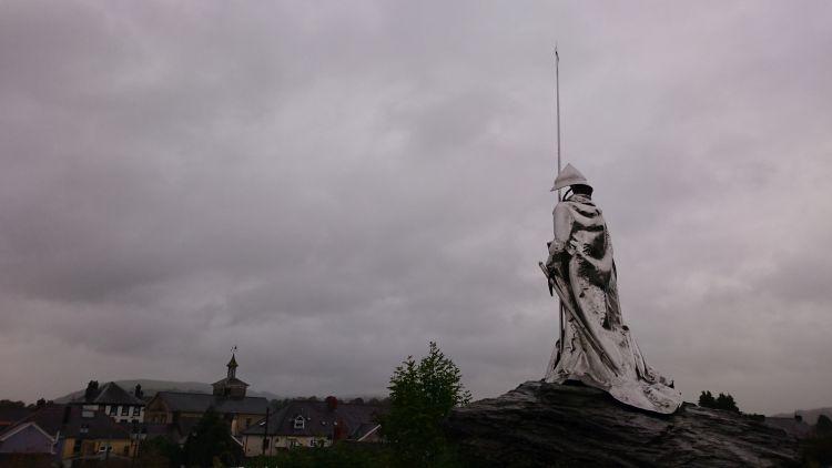 The steeley statue overlooks the town under heavy grey skies