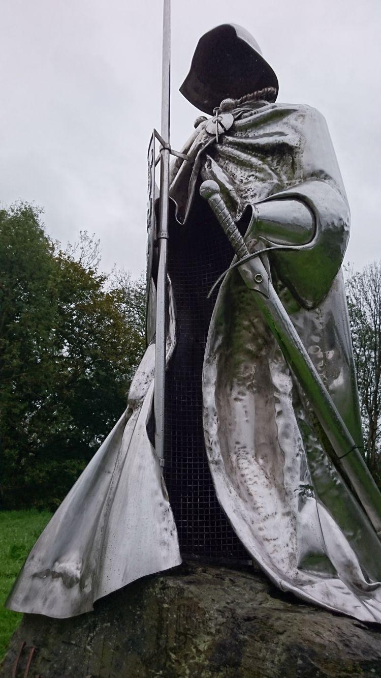 A steel statue of a robed warrior but there is no physical body, just the robe, helmet, sword and sheild