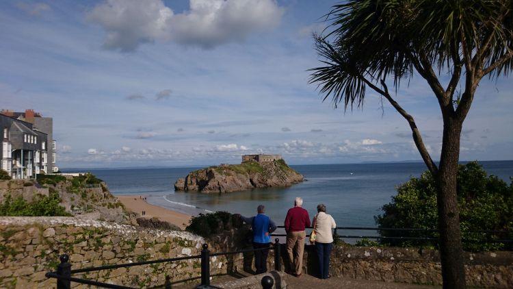 Between palm trees and holiday makers we see St Catherine's island out to sea from Tenby