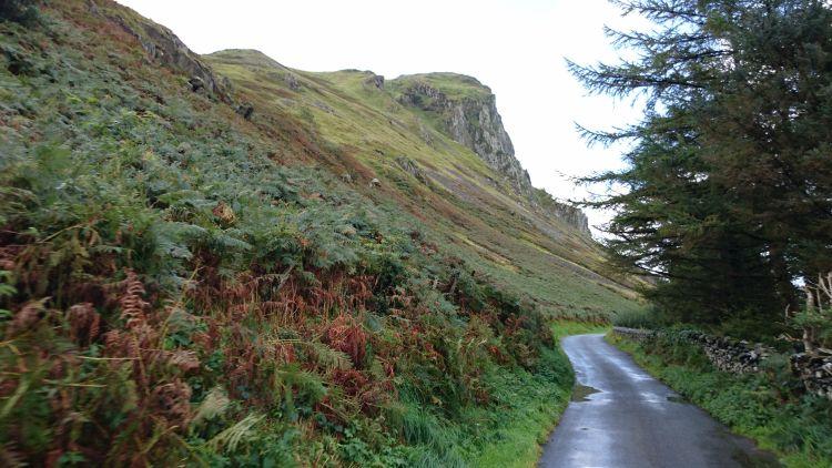 Steep fern covered hillsides, rocky outcrops and farmland in Wales