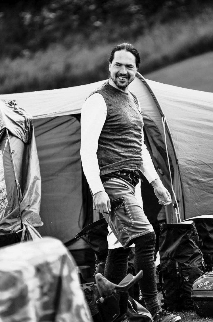 Ren is smiling emerging from the tent in an artistic black and white shot