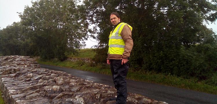 Ren looks into the camera while stood on a section of Hadrian's Wall. IT's raining a lot