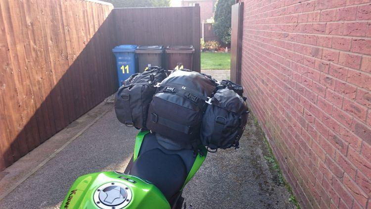 Three black bags tightly packed rest on the narrow rear seat of Sharon's Kawasaki