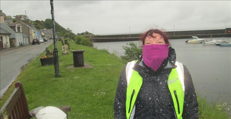 Sharon has her scarf over most of her face in the heavy rain at Helmsdale