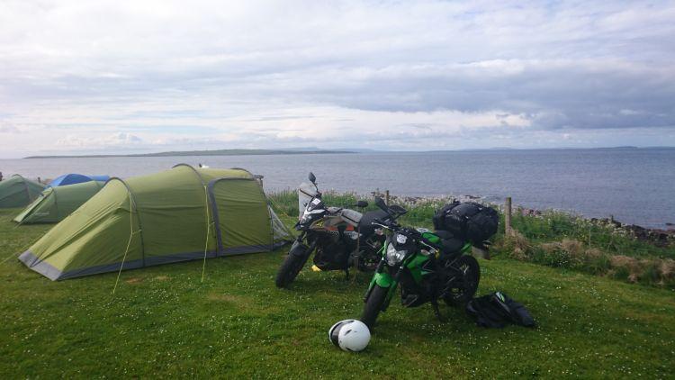 The tent and the 2 motorcycles pitched up at the campsite with the North Sea behind