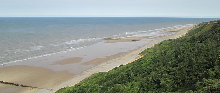 Small waves lap the sandy beach at Cromer, down below the bluffs