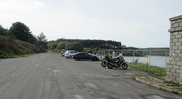 A broad car park, quiet among the hills and next to the reservoir