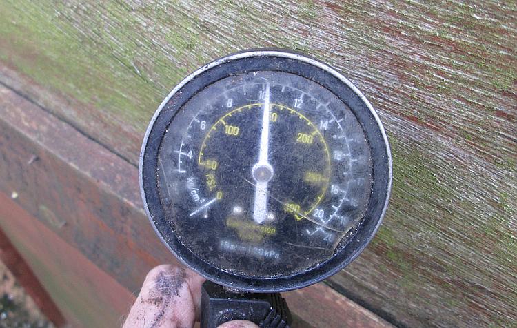 A worn out, scratched and bashed dial of the old compression tester, reading 145psi