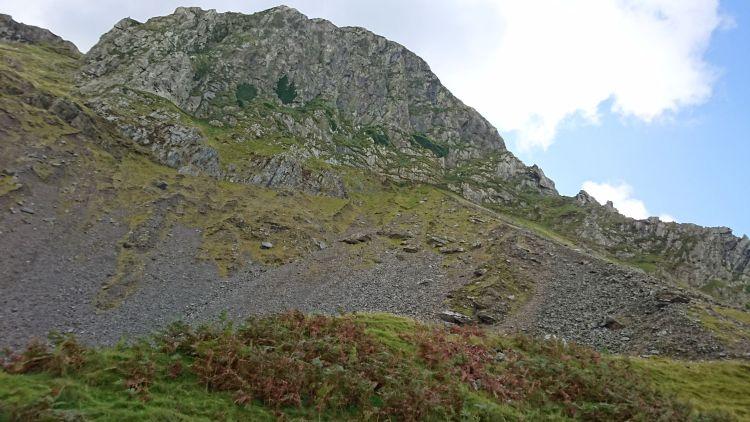 A large rocky outcrop forming a cliff atop a hill in mid wales