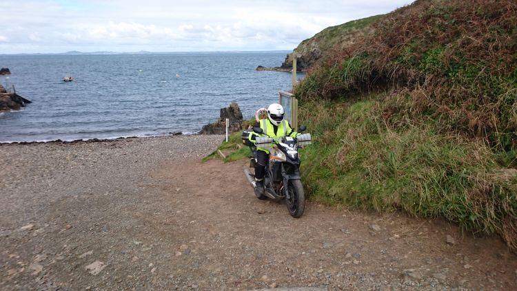 Ren on his motorcycle are facing inland now on a tiny shingle beach after turning around