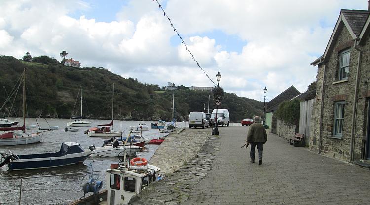 The windswept harbour of Lower town Fishguard. Boats, hills, walls and houses