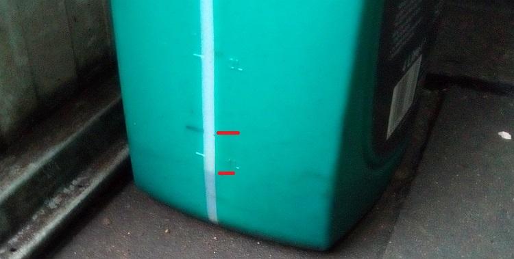 The marked level and the current level visible on the side of the oil container