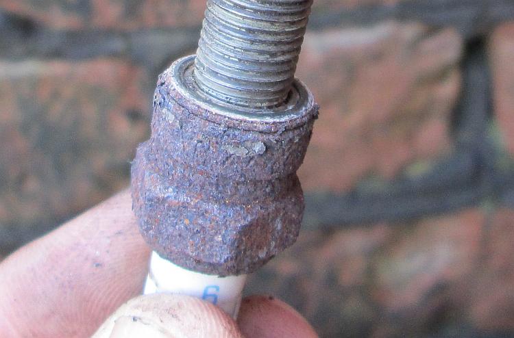A rusty and crusty metal body on the spark plug from the CBF125