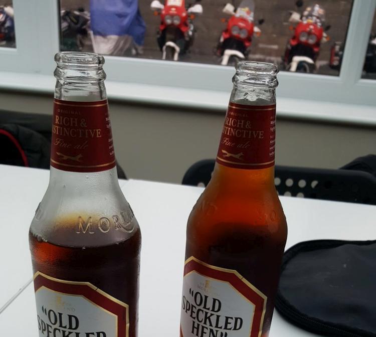 2 bottles of speckled hen beer with adventure motorcycles in the background