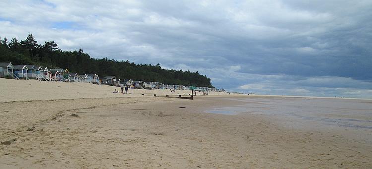 The wide sandy beach of wells-next-the-sea with beach huts at the edge