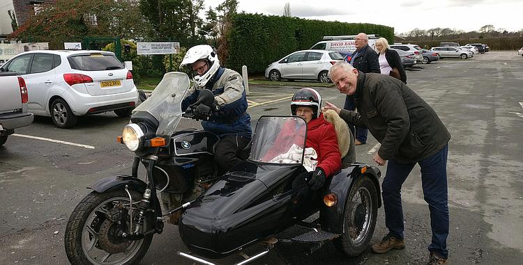 Annie is swaddled in the sidecar with Phil riding and David beside her