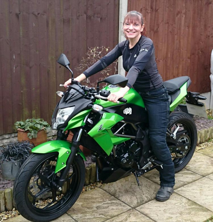 Sharon is sat on her Kawasaki Z250SL smiling and happy