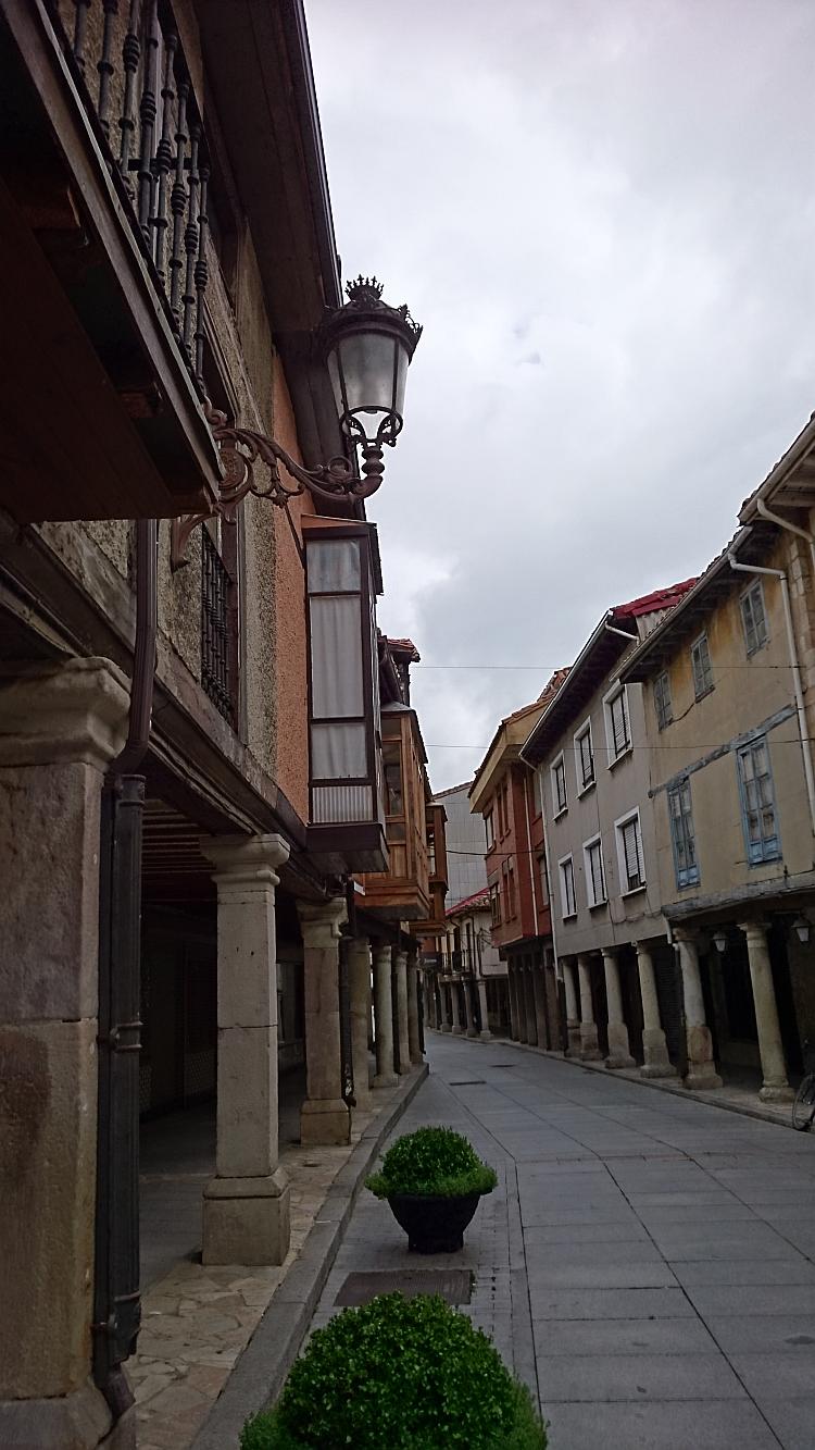 The narrow lane of the town and the buildings hang overhead