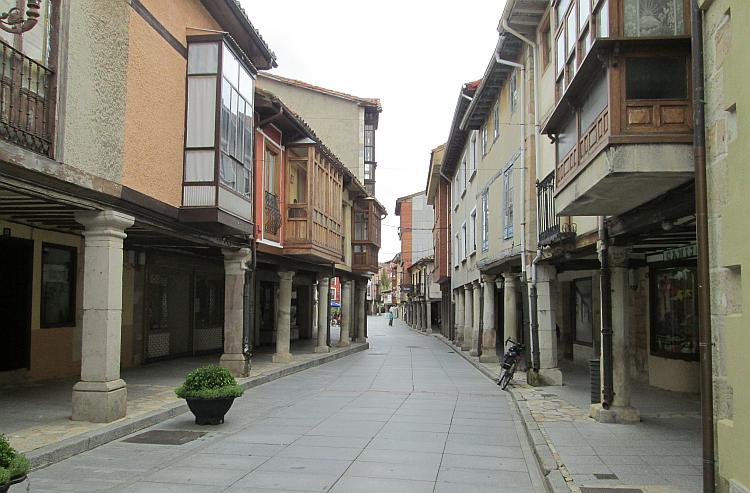 A narrow street with the houses and shops almost overhanging into the lane