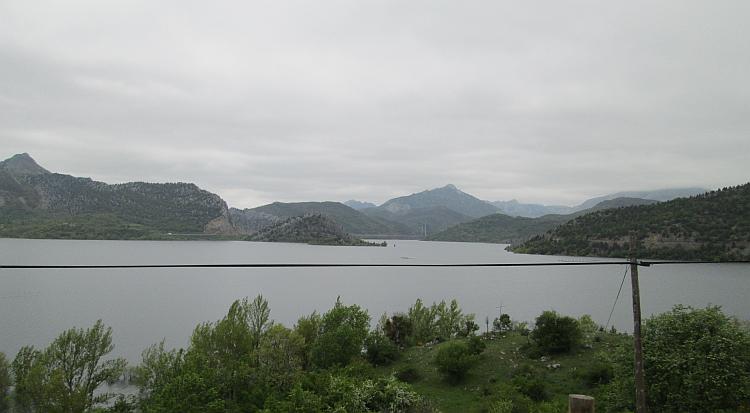 Looking across the reservoir we see endless mountains stretching out to the grey skies
