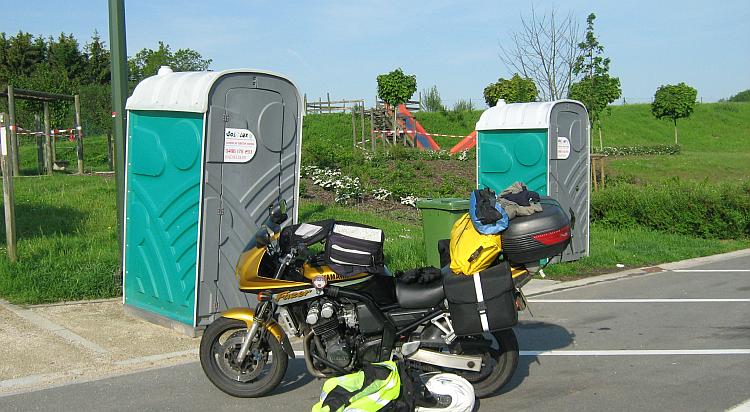 2 portaloos and a car park with a playground, a French service stop