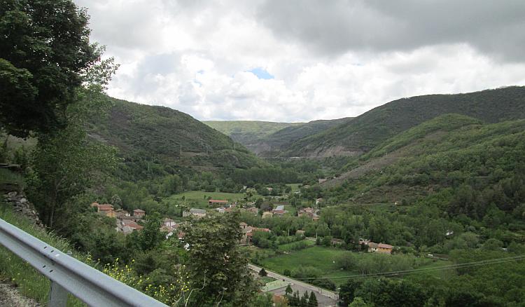 A village is deep down in the valley surrounded by steep hillsides in Northern Spain