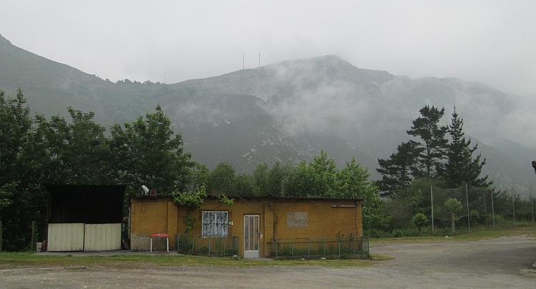 A misty hilly backdrop to a ramshackle hut by the side of the N634 in Northern Spain