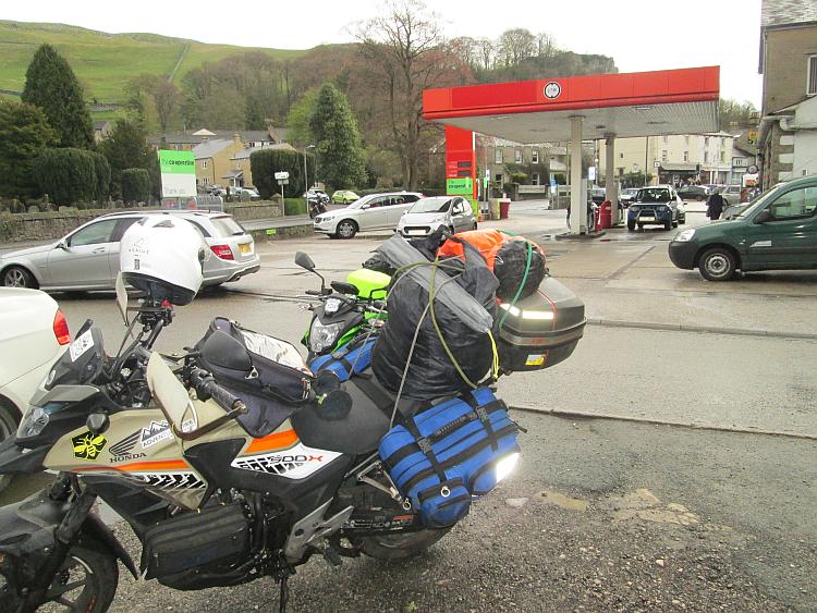 The petrol station at Settle with stone houses and green hills in the background