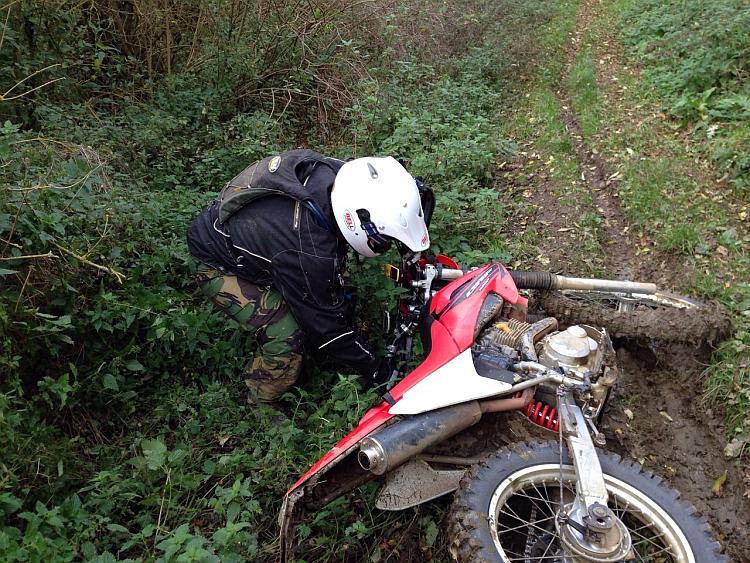 A rider is about to lift his dropped Honda CRF230