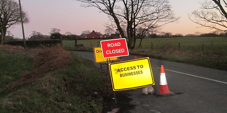 3 signs showing road closed, diversion and access to businesses only