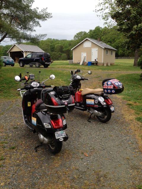 2 scooters with luggage and stickers at a Virginian farm