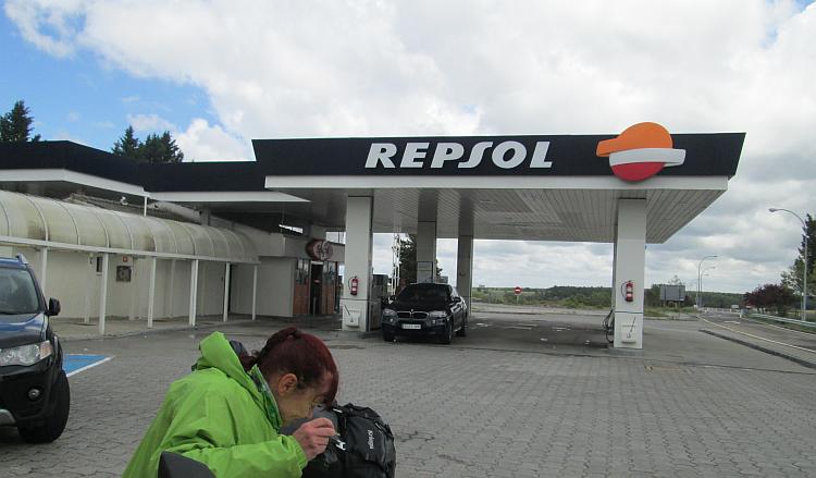 An ordinary Repsol garage in Spain and Sharon looking at something on her bike seat