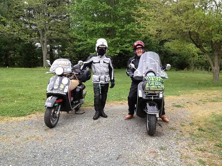 Stephen and Rick in their riding kit with their scooters ready to roll
