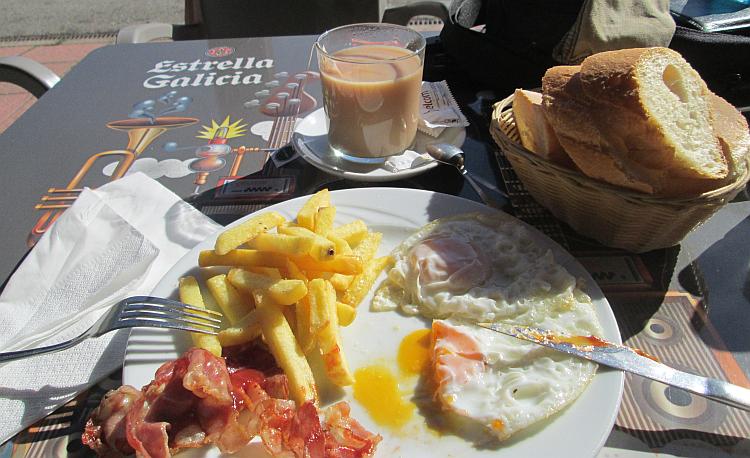 A plate with bacon chips egg and a cup of tea looking very tasty at camping de la demanda