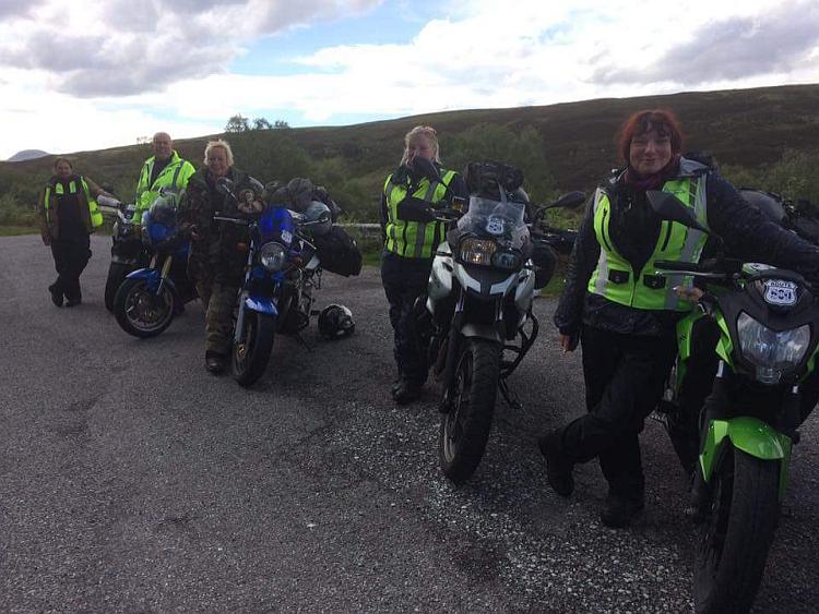 Sharon, Ren and some other biker all posing for the camera on a Highland road