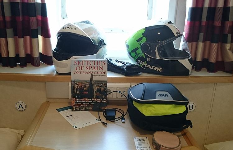 2 helmet in the window recess and a book on the small table between the beds of the Ferry cabin