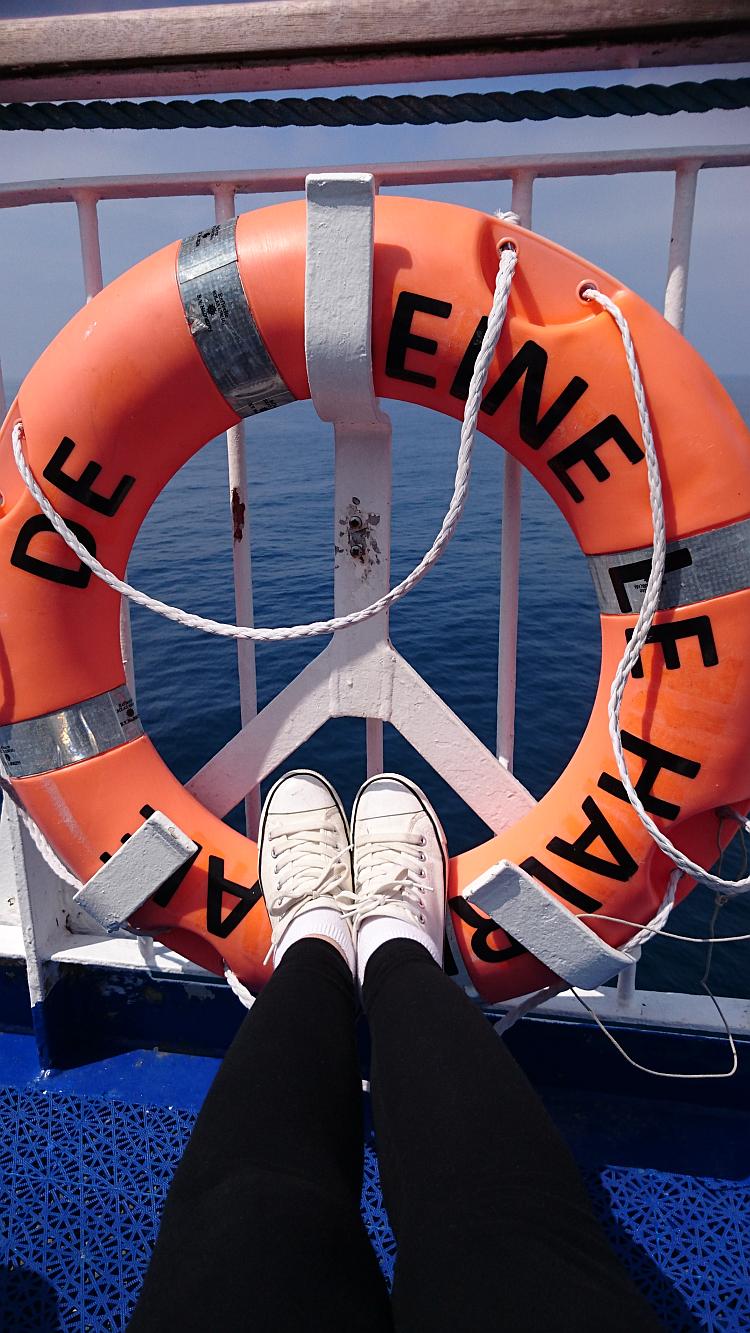 Sharon's feet are resting in the centre of a bright orange ring lifebelt on the ferry