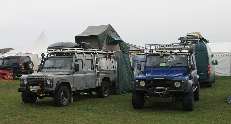 2 Land Rovers set up for overland travel with fold out tents on the roof.
