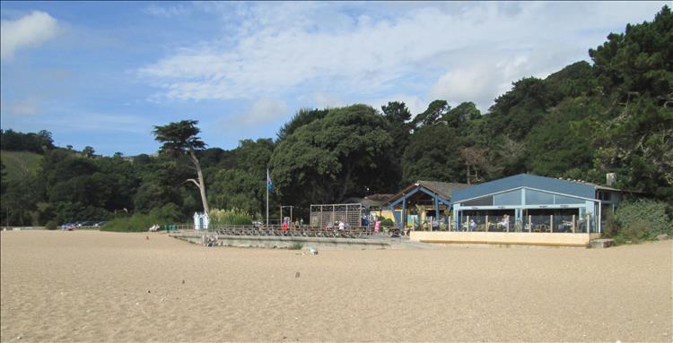 A beach hut type cafe among trees and sands at Blackpool Sands