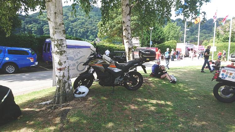 Ren's CB500X between 2 trees and with the BAT banner at the Bike Fest