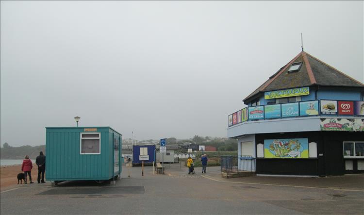 Closed shops, a container, grey skies and mist at Goodrington Sands
