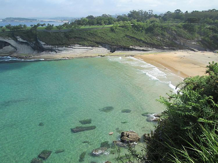 Turquoise waters and golden sands, steep cliffs and a small horseshoe bay in Santander