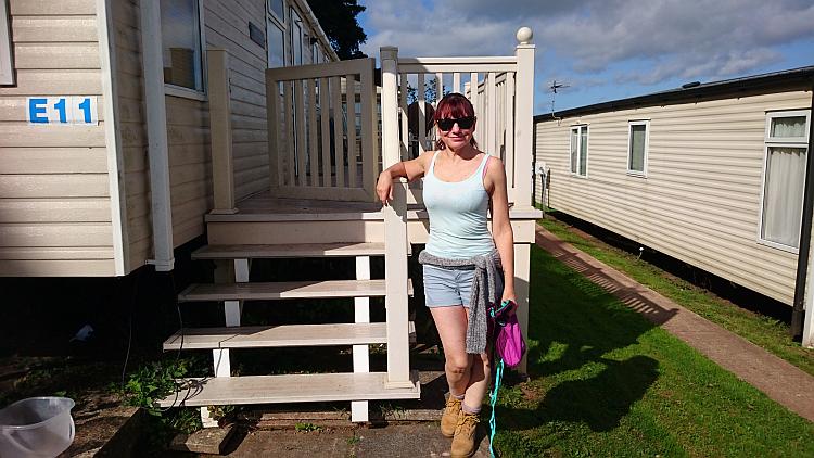 Sharon in shorts and vest and shade in the sunshine at the caravan near Brixham