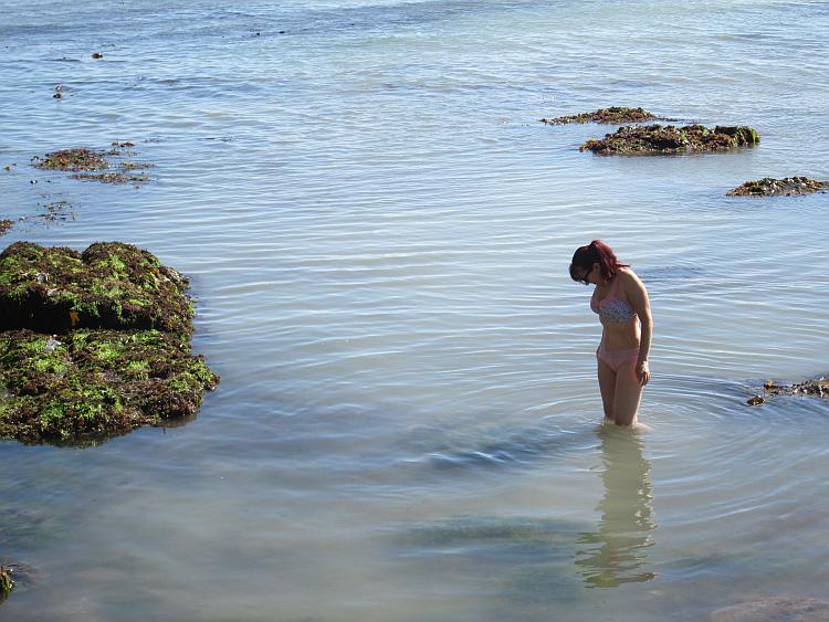 Sharon in her underwear stood up to her knees in the sea on the coast of devon