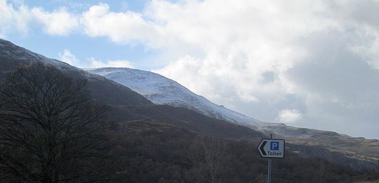 One rounded mountain in North Wales has a good layer of snow under light cloud and blue skies