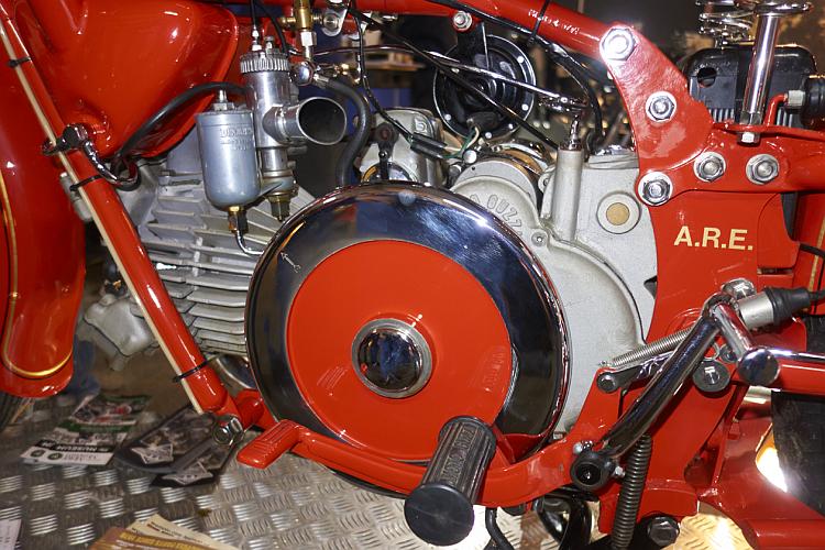A classic or vinage motorcycle engine with a bright red frame and flywheel