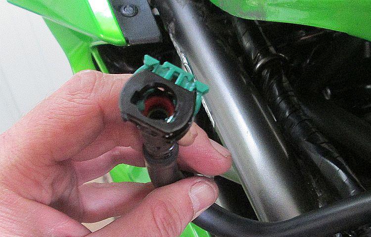 The end of the fuel pipe has a connector with a green tab to lock into place